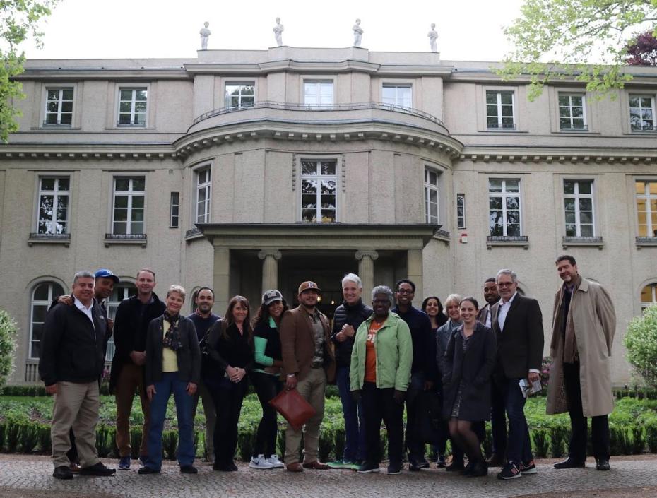 A group of Soros prosecutors smile outside the building where the Holocaust was plotted.